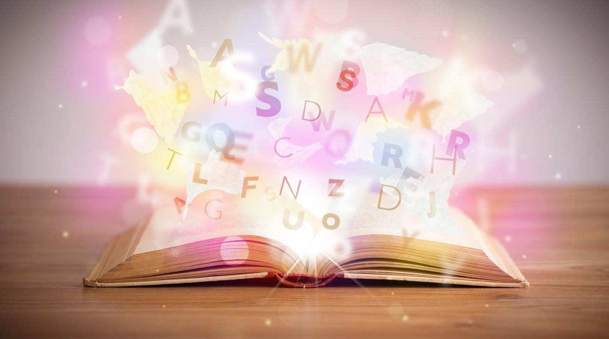 Open book with colorful letters bursting out